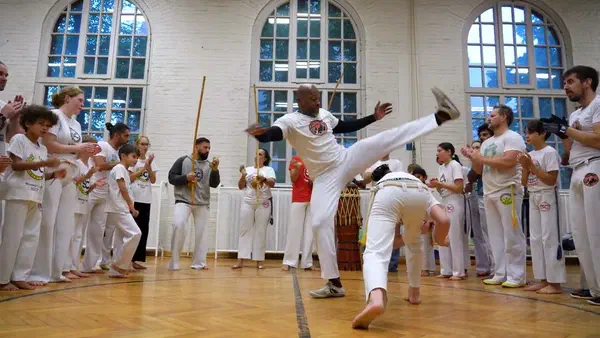 Two capoeiristas play in the roda while the group watches